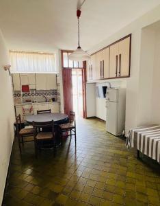 a kitchen with a table and chairs and a refrigerator at Lido del Sole bilo 28 in Rodi Garganico