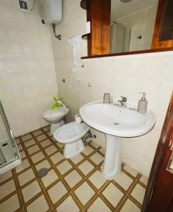 a bathroom with a sink and a toilet at Lido del Sole bilo 28 in Rodi Garganico +7 photos