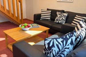 a living room with a couch and a table with a bowl of fruit at Scandi Style Bracken Lodge with Private Decking Sleeps 6 in Chudleigh Knighton