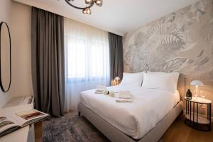 a bedroom with a large white bed and a window at Boutique Suites in Lugano
