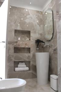 a bathroom with a white sink and a mirror at Aurea Rooms in Porto Cesareo