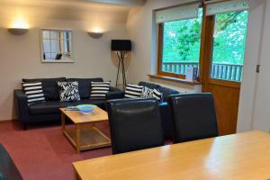 a living room with a couch and a table at Scandi Style Bracken Lodge with Private Decking Sleeps 6 in Chudleigh Knighton +67 photos