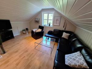 a living room with a black leather couch and a table at Aurlandsdalen in Aurland