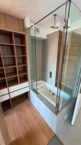 a bathroom with a glass shower and a tub at Duplex Premium Ciudad Jardín in El Palomar +34 photos
