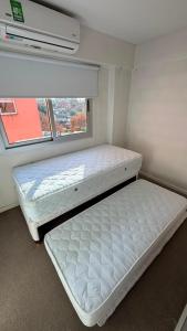 a bedroom with two beds in a room with a window at Duplex Premium Ciudad Jardín in El Palomar