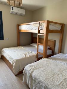 a bedroom with two bunk beds and a fan at D bay north coast chalet in El Dab‘a