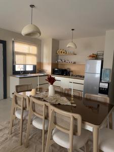 a kitchen with a table and chairs and a refrigerator at D bay north coast chalet in El Dab‘a +10 photos