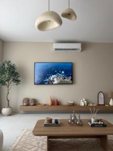a living room with a tv on the wall at D bay north coast chalet in El Dab‘a