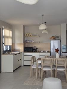 a kitchen with a table and chairs and a refrigerator at D bay north coast chalet in El Dab‘a