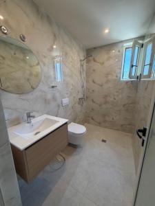 a bathroom with a sink and a toilet at Villa MarJon in Vlorë +13 photos
