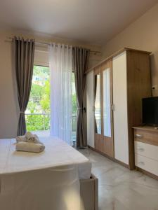 a bedroom with a bed and a large window at Villa MarJon in Vlorë