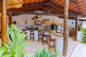 a bar with wooden stools in a room at Hotel Pousada 360 in Paracuru