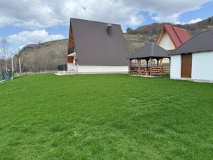 a large green field with a large building at Veruša - Maksim's house in Veruša