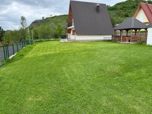 a large grassy yard with a building and a house at Veruša - Maksim's house in Veruša
