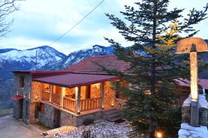 a house with a deck and mountains in the background at Erofili in Kato Trikala Korinthias