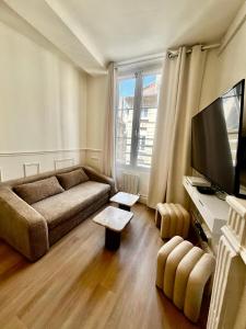 a living room with a couch and a flat screen tv at Appartement hyper centre de Caen, refait à neuf, cosy in Caen