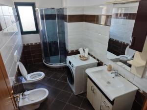 a bathroom with a toilet and a shower and a sink at Dua 1 Apartments Shkoder in Shkodër +30 photos