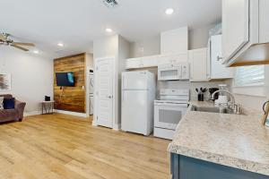 a kitchen with white cabinets and a white refrigerator at Gone Coastal Cottage in Rockport