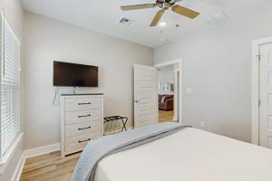 a bedroom with a bed and a flat screen tv at Gone Coastal Cottage in Rockport