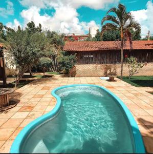 a swimming pool in a yard with a house at Pousada Caravelas in São Miguel do Gostoso