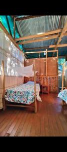 a bedroom with two beds on a wooden floor at Greenland Eco Amazon Lodge in Paucartambo