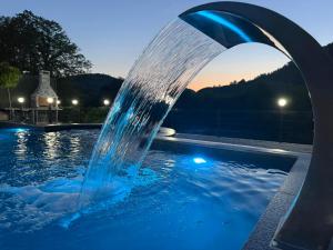 a water fountain in a swimming pool at night at Villa Lux Una in Bosanska Krupa