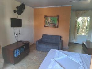 a living room with a bed and a couch at Pousada Encanto dos Olhos in Alexânia +14 photos