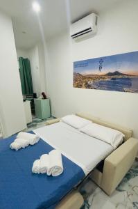 ein Schlafzimmer mit einem Bett, auf dem zwei Handtücher liegen in der Unterkunft Tp luxury in Neapel
