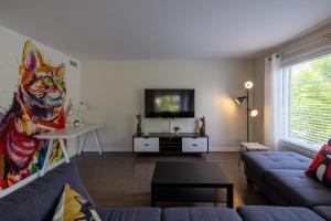 a living room with a couch and a tv at EdenCat Condo - Mountain View in Beaupré