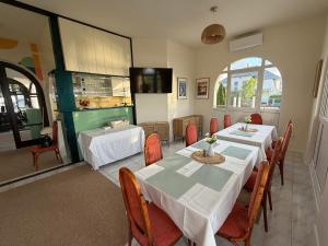 a dining room with two tables and chairs and a kitchen at Aranyhídszálló in Balatonboglár