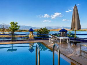 a pool at a resort with an umbrella at Rive Du Lac in Lalla Takerkoust