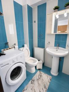 a bathroom with a washing machine and a sink at My Chios Apartments in Chios