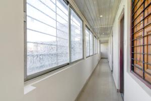 an empty hallway with large windows in a building at Hotel O Kanchenjunga Stadium Formerly Bindhan's Inn in Siliguri +27 photos
