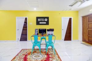 two blue chairs in a room with yellow walls at OYO Hotel O Amaravathi Road Annapurna Nagar in Guntūr +33 photos