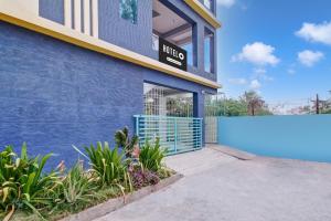a blue building with a blue gate and plants at OYO Hotel O Amaravathi Road Annapurna Nagar in Guntūr