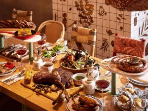 a table topped with plates of food and glasses of wine at Mama Shelter Dijon in Dijon