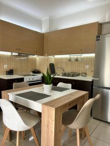 a kitchen with a table and chairs and a refrigerator at My Chios Apartments in Chios