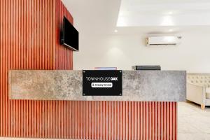 a lobby with a counter with a sign on it at Super Townhouse Oak Sector 39 Medanta in Gurgaon