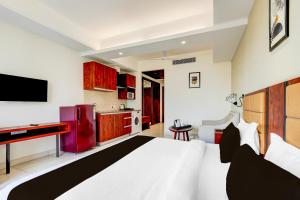 a bedroom with a white bed and a red refrigerator at Super Townhouse Oak Sector 39 Medanta in Gurgaon