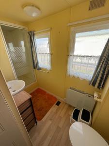 a small bathroom with a sink and a mirror at Bell Bank C8 - pet friendly, bed linen, close to bars and shops - Meadow Lakes Caravan & Lodge Hire in Chapel Saint Leonards