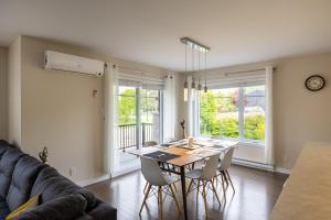 a living room with a table and chairs and a couch at EdenCat Condo - Mountain View in Beaupré