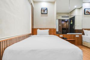 a bedroom with a large white bed and a bathroom at Palette by CheckIn Chappan Market Indore Formerly Sapphire Star in Indore +31 photos