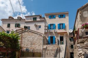 an old building with blue windows in an alley at Agava Design Residence in Split