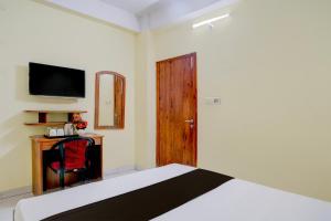 a bedroom with a bed and a television on the wall at Super Collection O Bashista Chariali Formerly Luit Heritage in Dispur