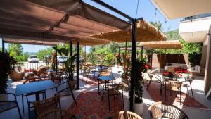 a patio with tables and chairs under umbrellas at White Hill by Fllad e Vale in Vlorë +42 photos