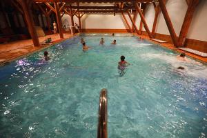 a group of people swimming in a swimming pool at Ośrodek Wypoczynkowy MAX in Jarnołtówek