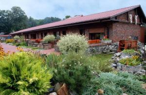 a brick house with a garden in front of it at Ośrodek Wypoczynkowy MAX in Jarnołtówek