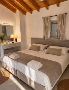 a bedroom with a large white bed with a mirror at Villa Armando Corfu Jacuzzi in Perama