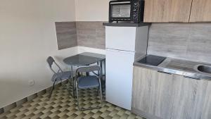 a small kitchen with a small table and a microwave at La casa de valras in Valras-Plage