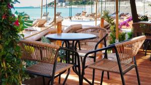 a table and chairs on a deck with a view of the water at White Hill by Fllad e Vale in Vlorë